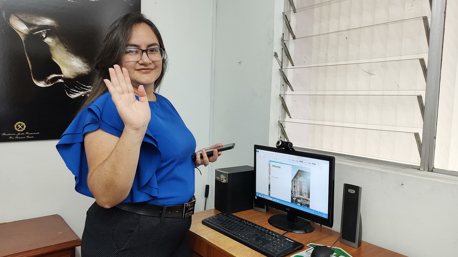 fotografía: Una mujer saludando la camara mientras sonrie